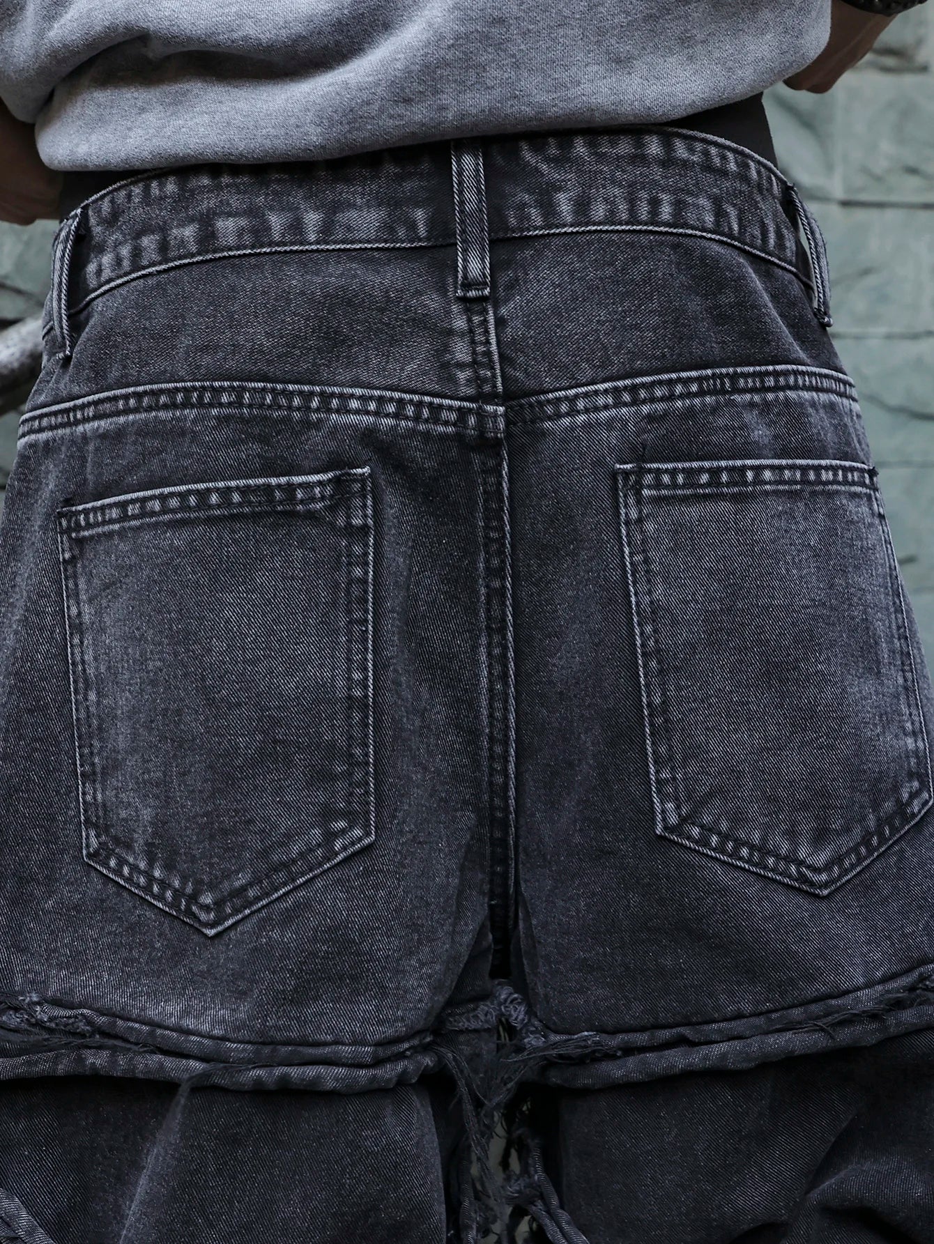 Men's black jeans. With a design of (ripped holes) and tassels. In a street trend style.