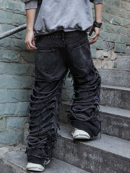 Men's black jeans. With a design of (ripped holes) and tassels. In a street trend style.