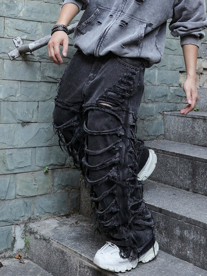 Men's black jeans. With a design of (ripped holes) and tassels. In a street trend style.