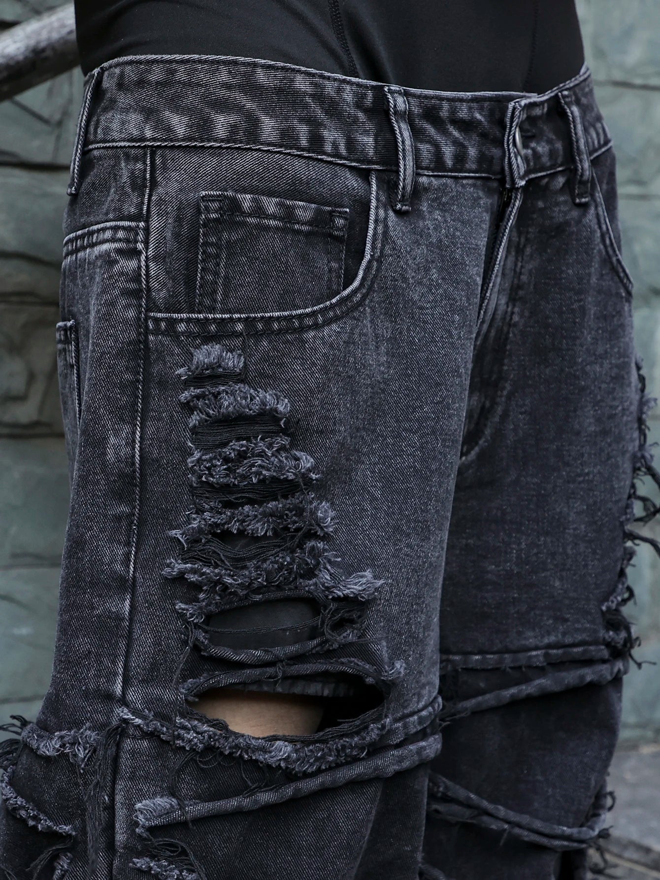 Men's black jeans. With a design of (ripped holes) and tassels. In a street trend style.